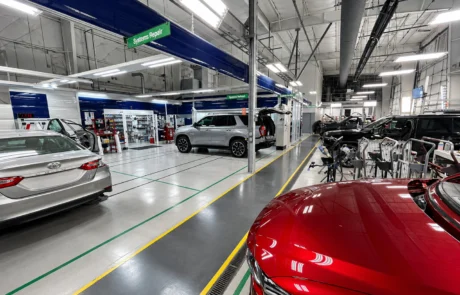 Collision repair production floor with systems repair stations and organized workflow layout