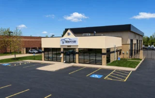 Front elevation of DCR Systems Mentor collision repair facility with customer parking area