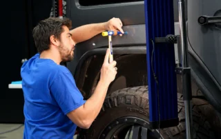 Technician performing auto body panel repair in Mentor, Ohio collision repair facility