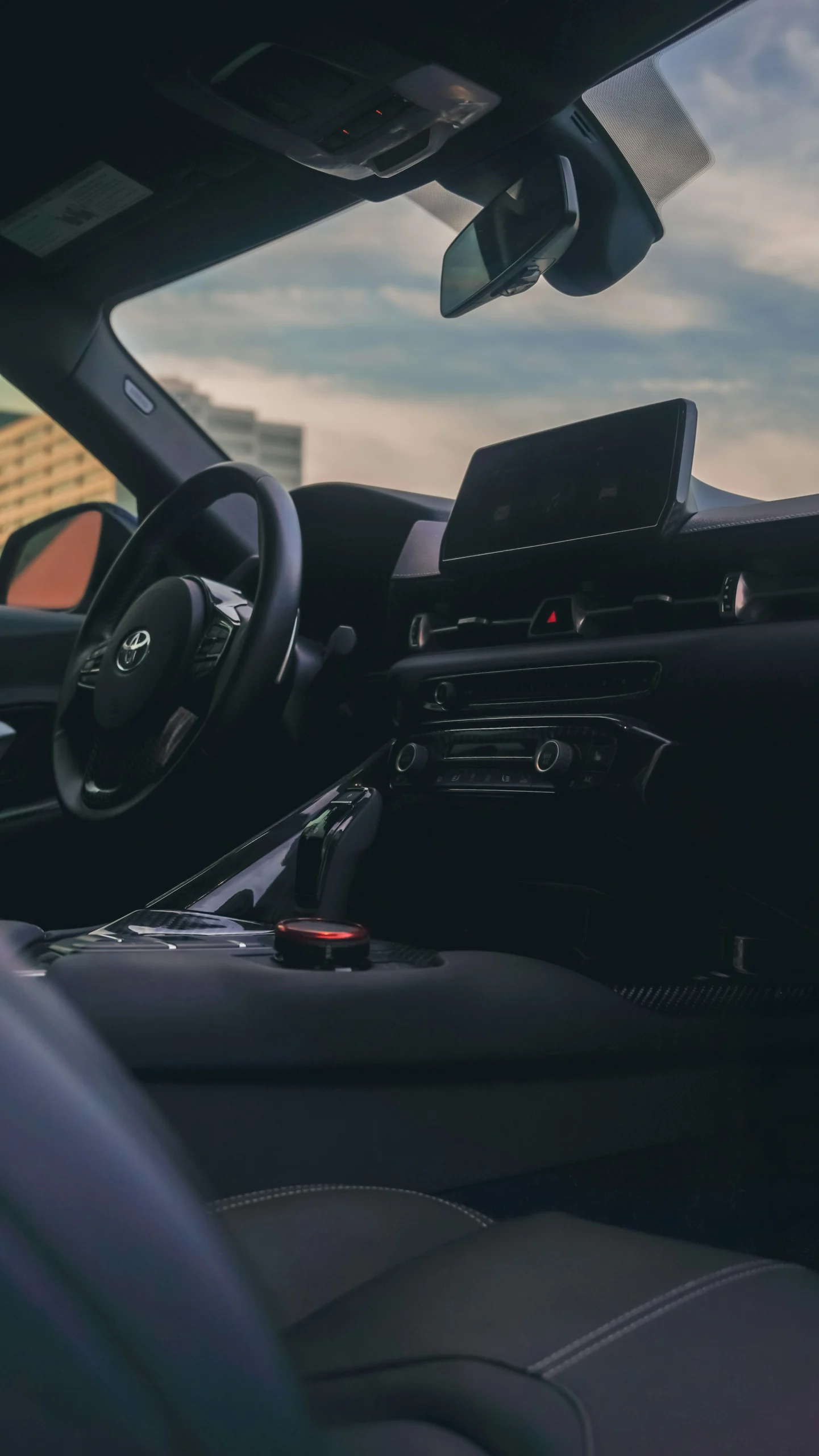 Toyota vehicle interior showing dashboard, infotainment screen, center console, and driver controls