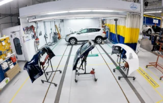 Automotive bumper panels staged for refinishing and paint preparation at DCR Systems Mentor collision repair facility